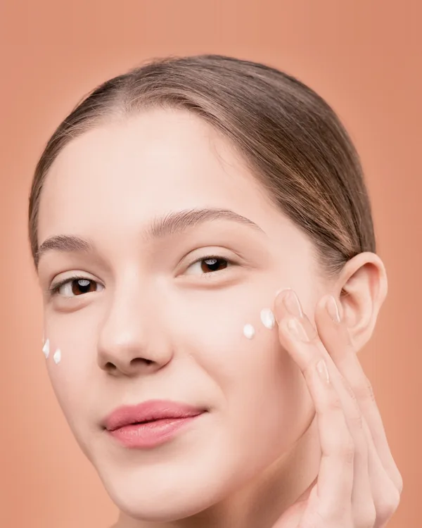 Femme avec des touches de crème sur la joue