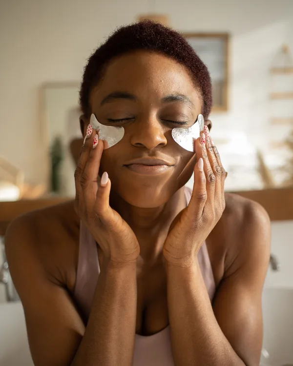 Femme avec des patchs sous les yeux le matin dans la salle de bain